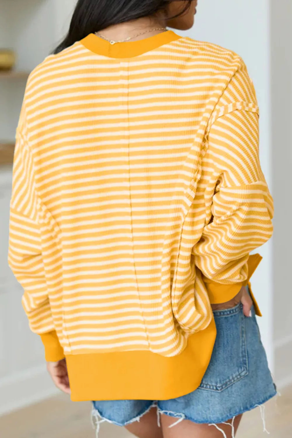 Yellow striped waffle-knit pullover with long sleeves and relaxed back silhouette
