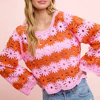Orange crochet knit top with pink flower pattern, long sleeves, scoop neck hem detail.