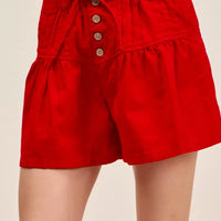 Red twill denim shorts with pintucks, button front, and waist tie; elastic waistband.