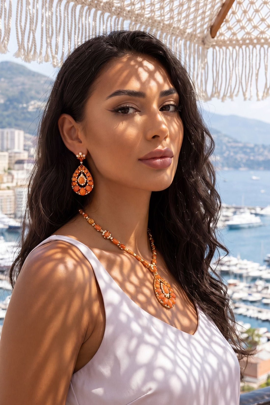 Gold-tone necklace with orange bead strand and large teardrop pendant with crystal halo