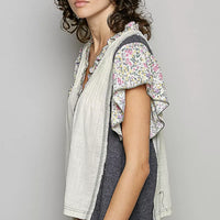 Cream V-neck blouse with floral ruffle sleeves and charcoal side panel detail