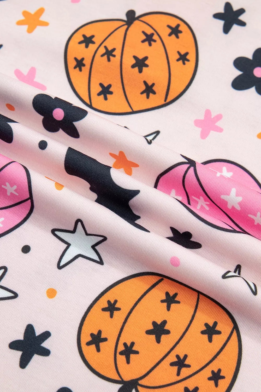 Pumpkin, stars and flower print pajama fabric close-up