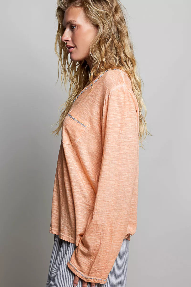 Peach lightweight knit top with long sleeves and V-neck contrast trim