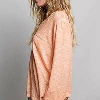 Peach lightweight knit top with long sleeves and V-neck contrast trim