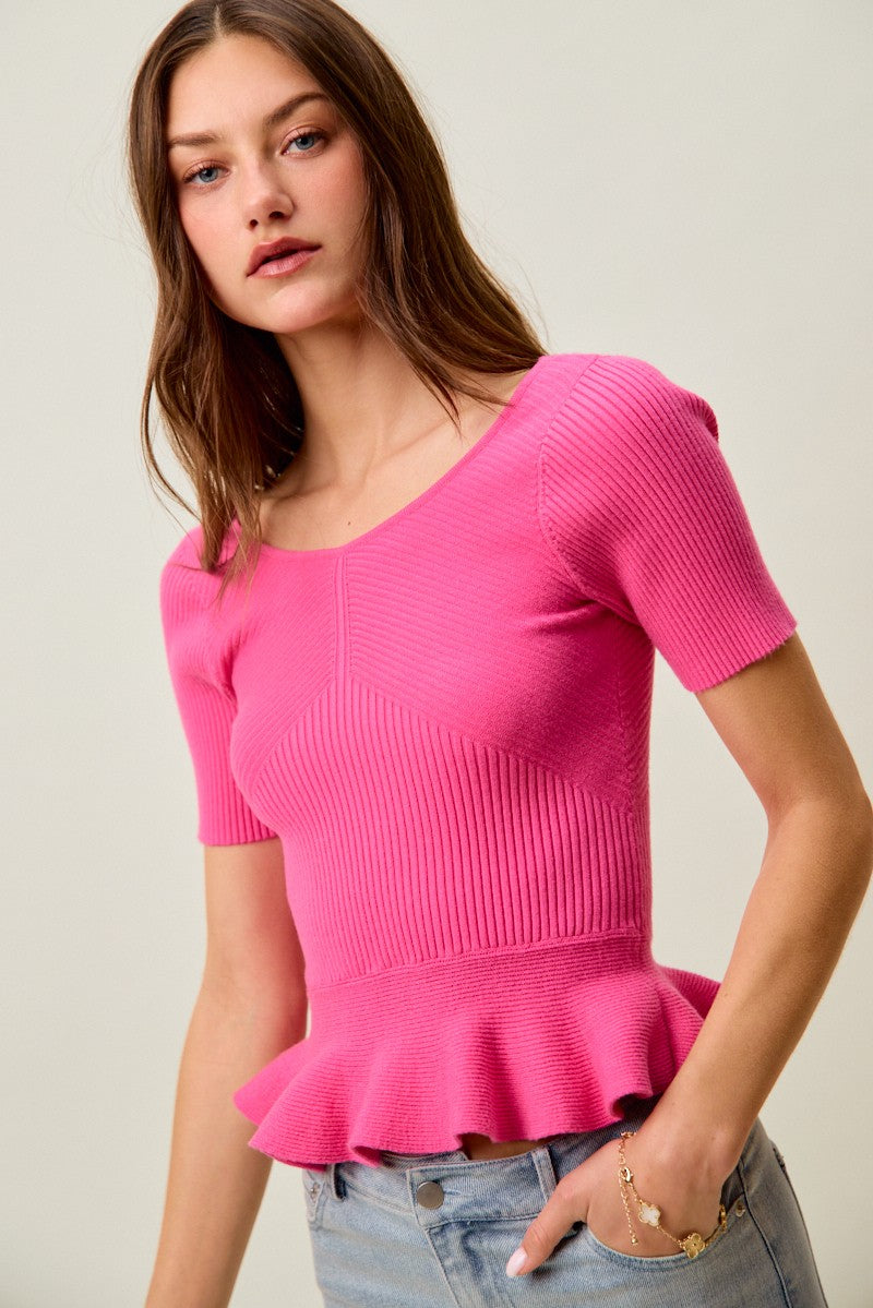 Hot pink ribbed knit sweater top with short sleeves and peplum ruffle hem