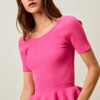 Hot pink ribbed knit sweater top with short sleeves and peplum ruffle hem