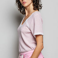 Baby pink textured V-neck short-sleeve T-shirt with white lace trim, side view