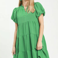 Green tiered babydoll dress with puff sleeves and V-neck, short length