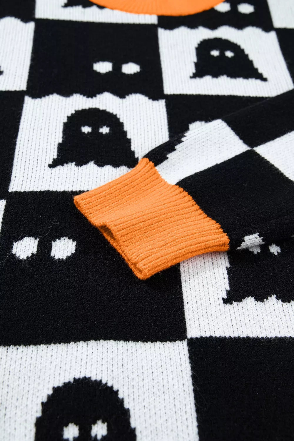 Black ghost checkerboard sweater with orange knit cuff detail