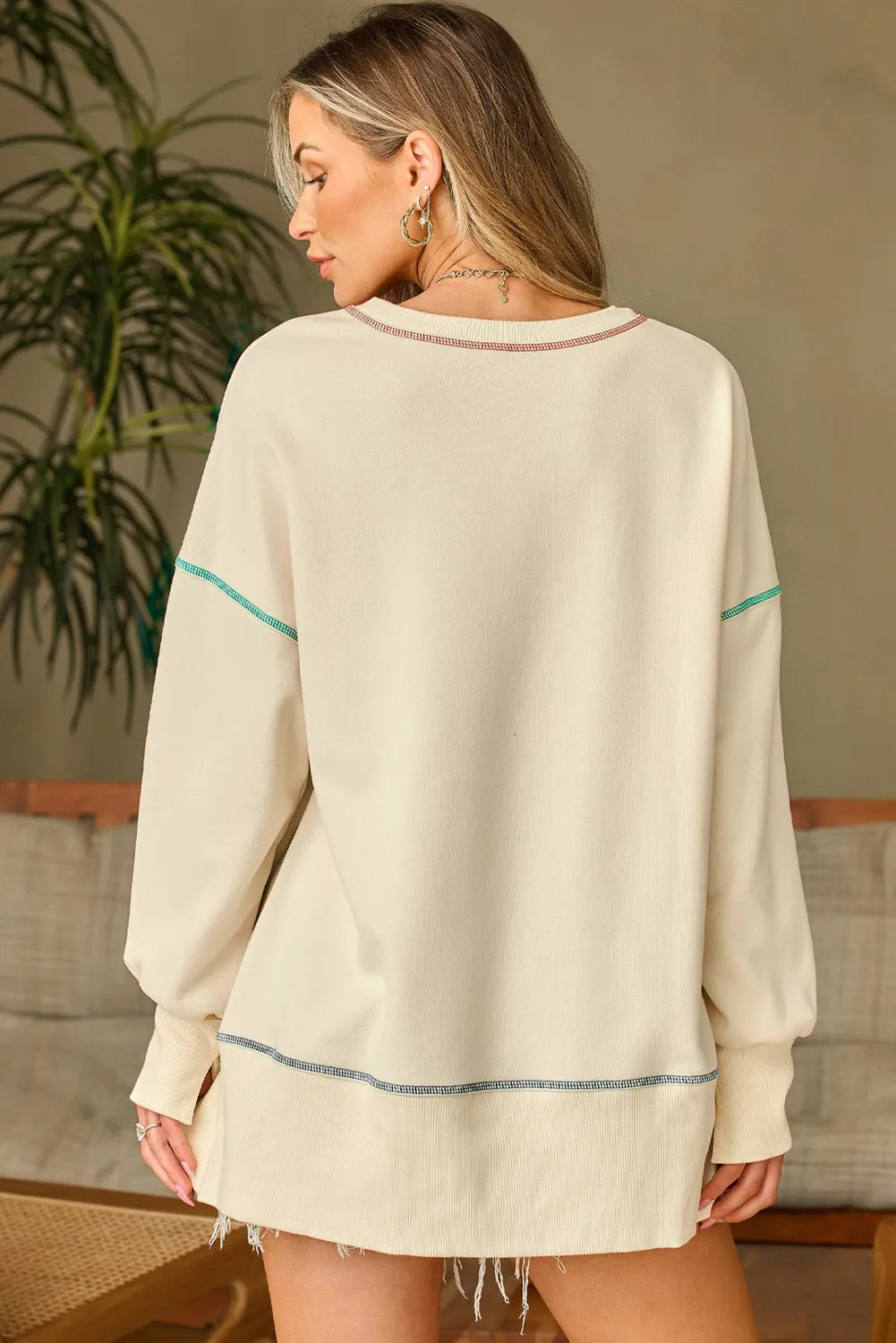 Ivory long-sleeve sweatshirt with contrast stitching, crew neck, and banded back