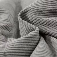 Gray corduroy puffer vest fabric close-up with ribbed texture and quilted padding layers.
