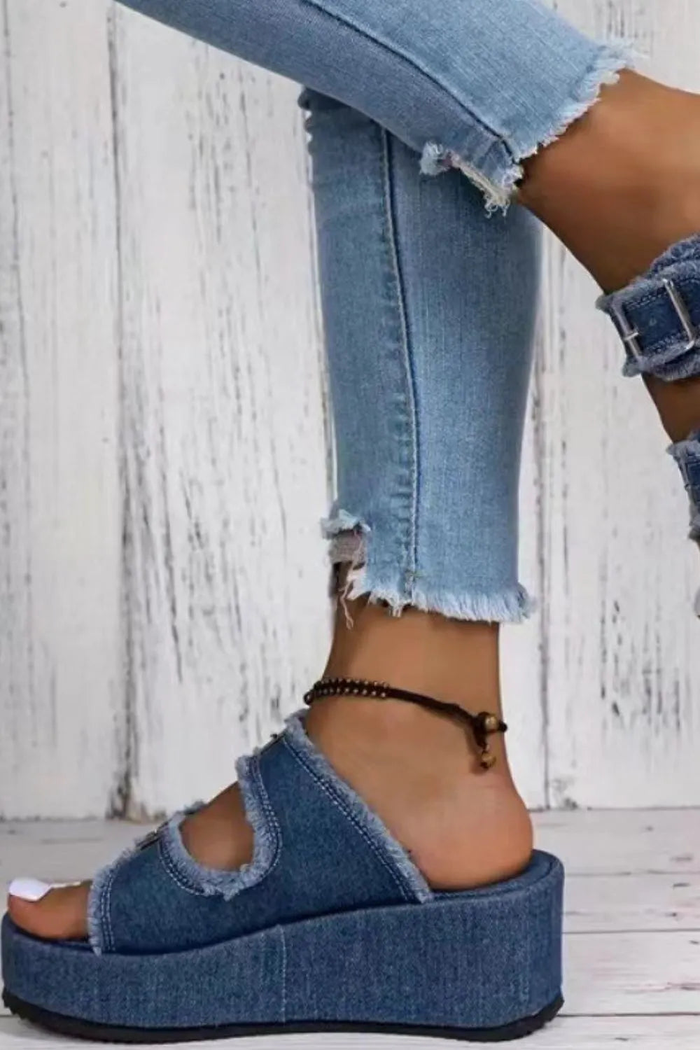 Blue denim wedge sandals with two adjustable straps and metal buckle hardware