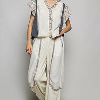 Cream V-neck blouse with floral ruffle sleeves and charcoal side panels, button front