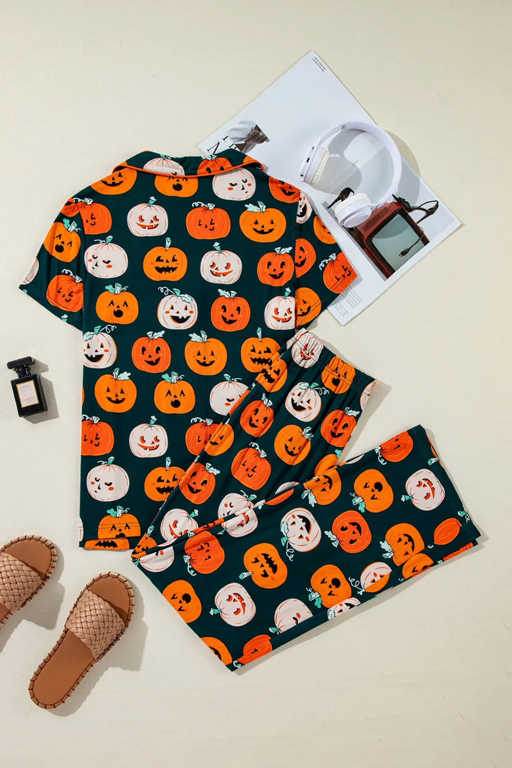 Flat lay of pumpkin-printed short-sleeve top and matching lounge pants, dark green
