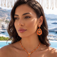 Orange gemstone statement necklace with gold-tone chain and teardrop pendant centerpiece