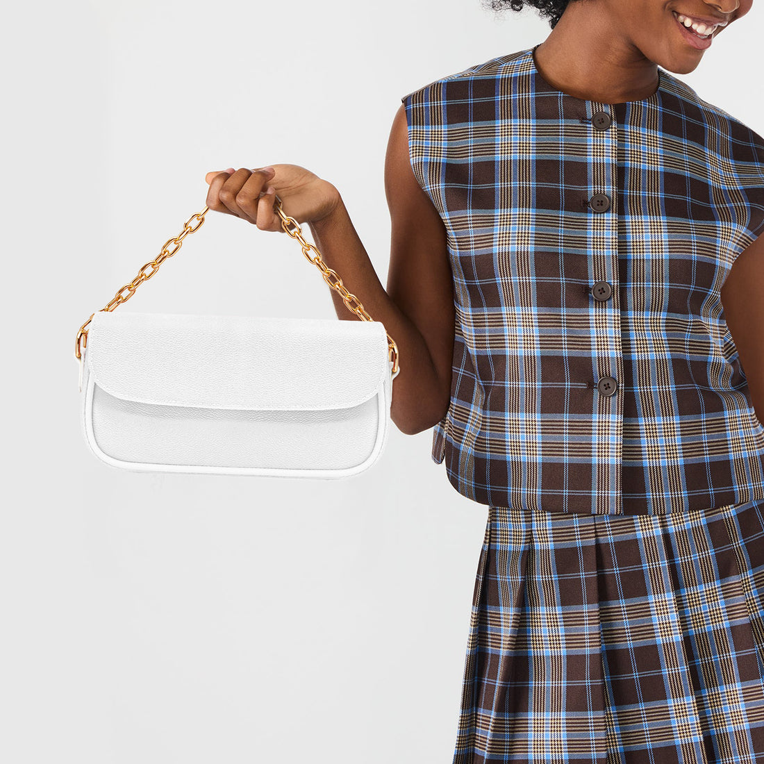 White mini shoulder bag with gold chain handle and curved front flap.
