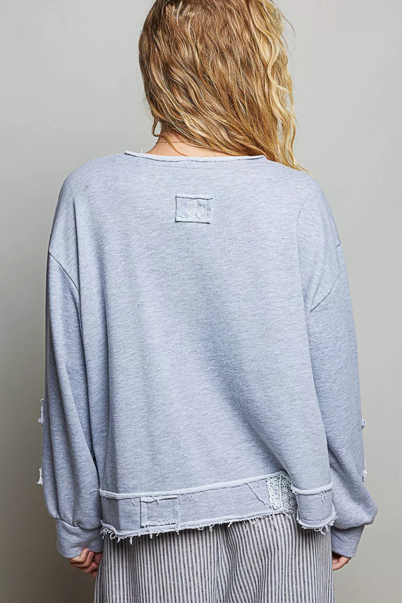Heather gray V-neck sweatshirt back view with raw hem and small patch detail