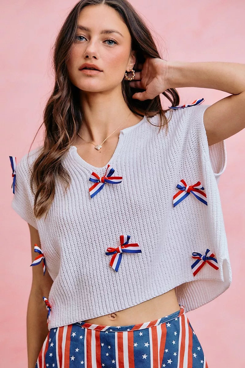 Off-white ribbed knit dolman sweater with red, white, and blue ribbon bows