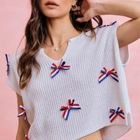 Off-white ribbed knit dolman sweater with red, white, and blue ribbon bows