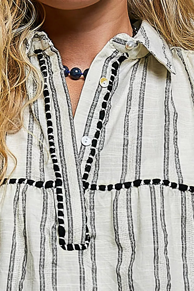 Grey multi-striped sleeveless cotton top close-up with button collar and black trim
