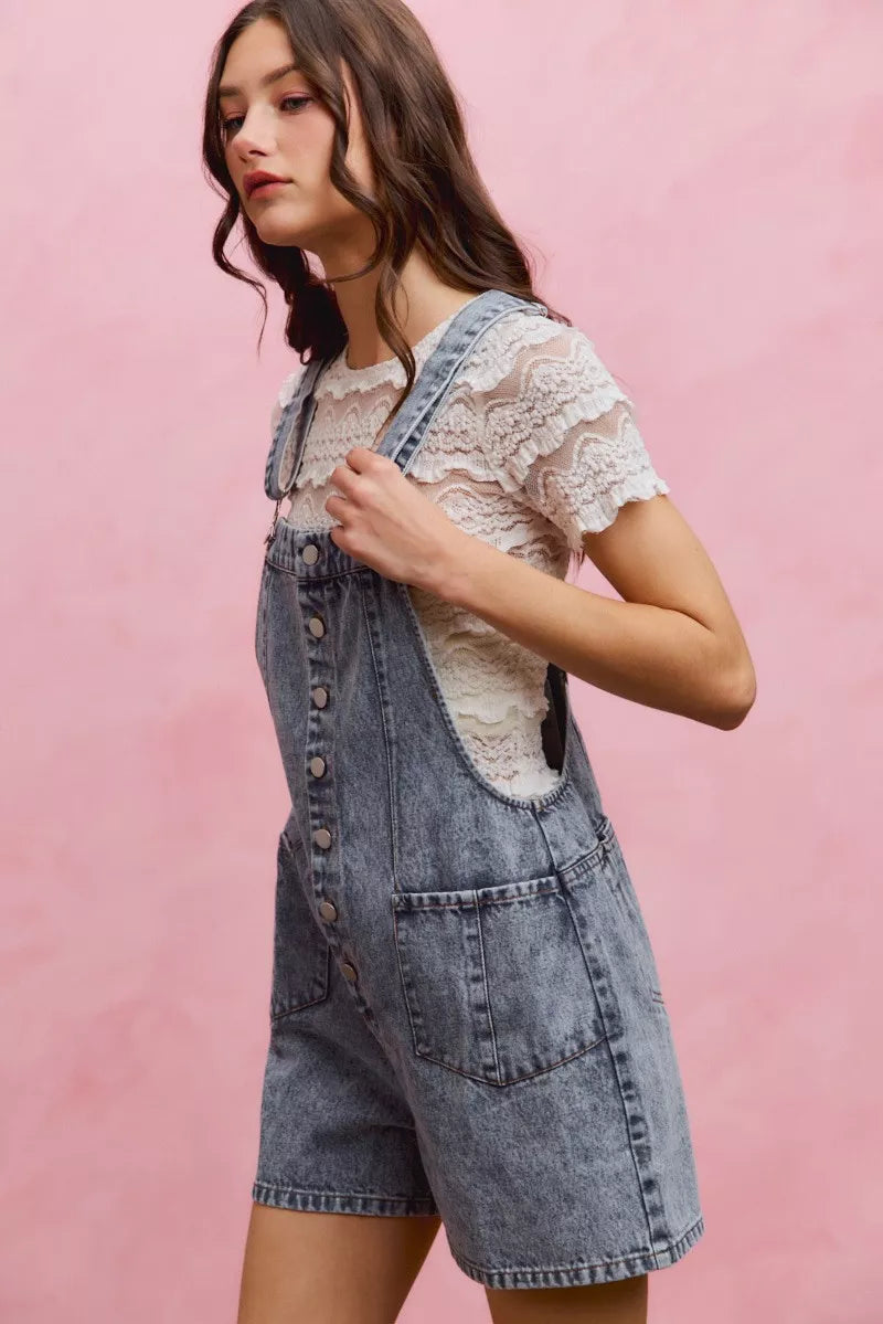Light wash denim overall romper with adjustable straps and front button placket, side pockets