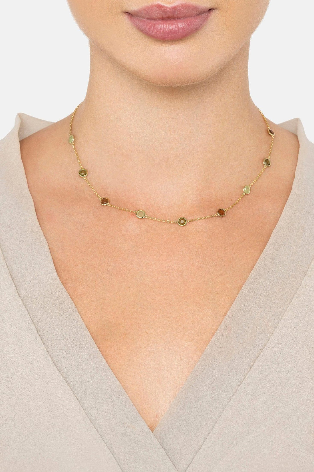 Gold chain necklace with oval green stones and brown discs on collar