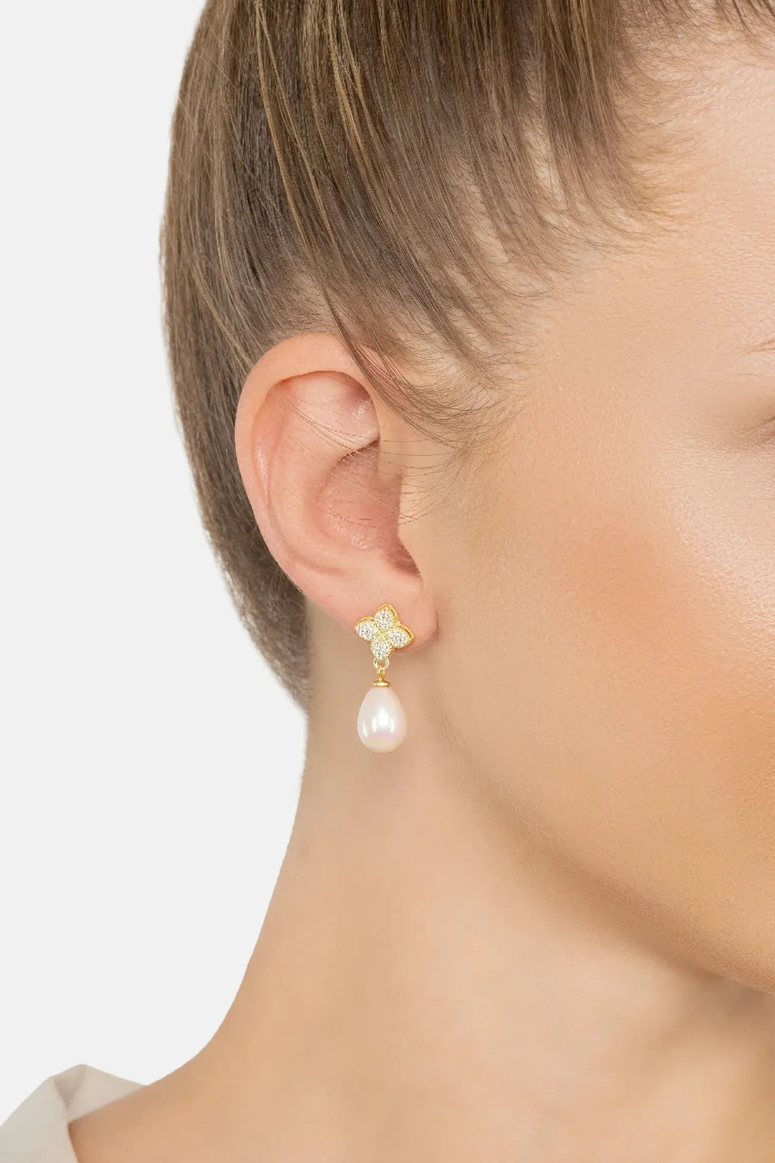 Gold clover CZ earrings with dangling white pearl drop on ear