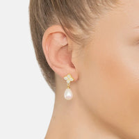 Gold clover CZ earrings with dangling white pearl drop on ear