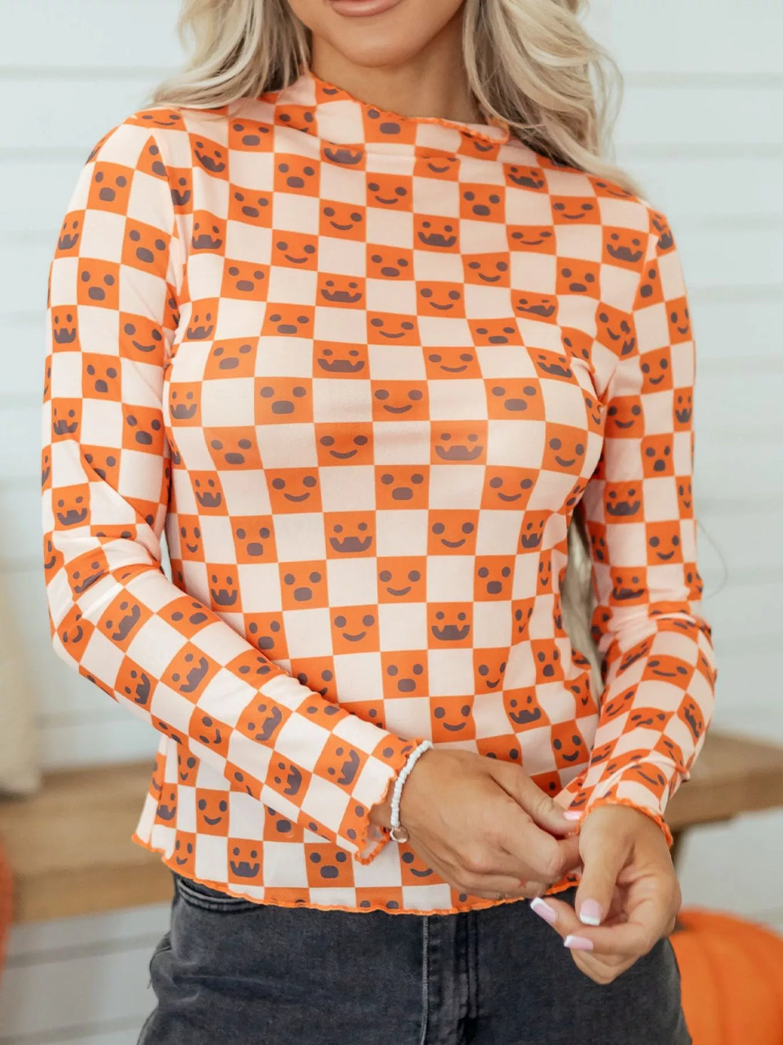 Halloween long sleeve mock neck blouse in orange-and-white checker with jack-o’-lantern faces