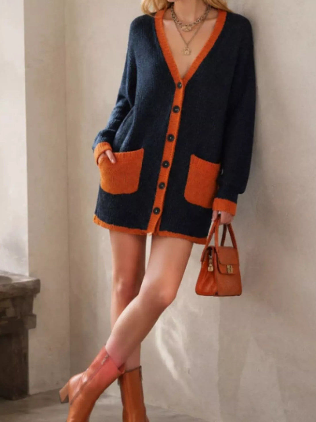 Dark navy knit V-neck cardigan with orange trim, button front, and patch pockets