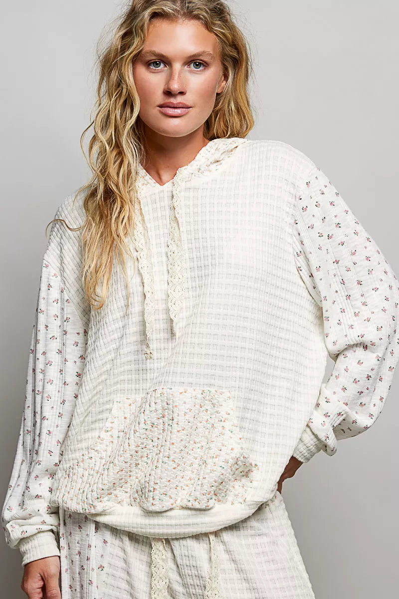 Cream knit pullover hoodie with floral-print sleeves and kangaroo pocket