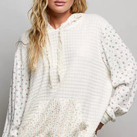 Cream knit pullover hoodie with floral-print sleeves and kangaroo pocket
