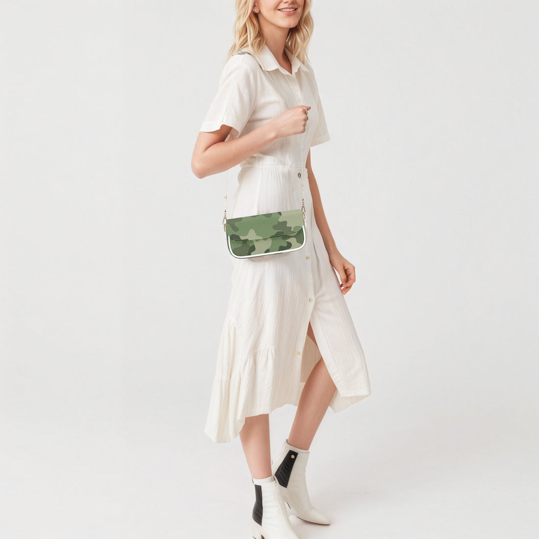 Green camouflage crossbody shoulder bag with flap front and white strap, worn over dress.