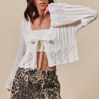 Off-white textured cardigan with bow-tied open front and draped long sleeves