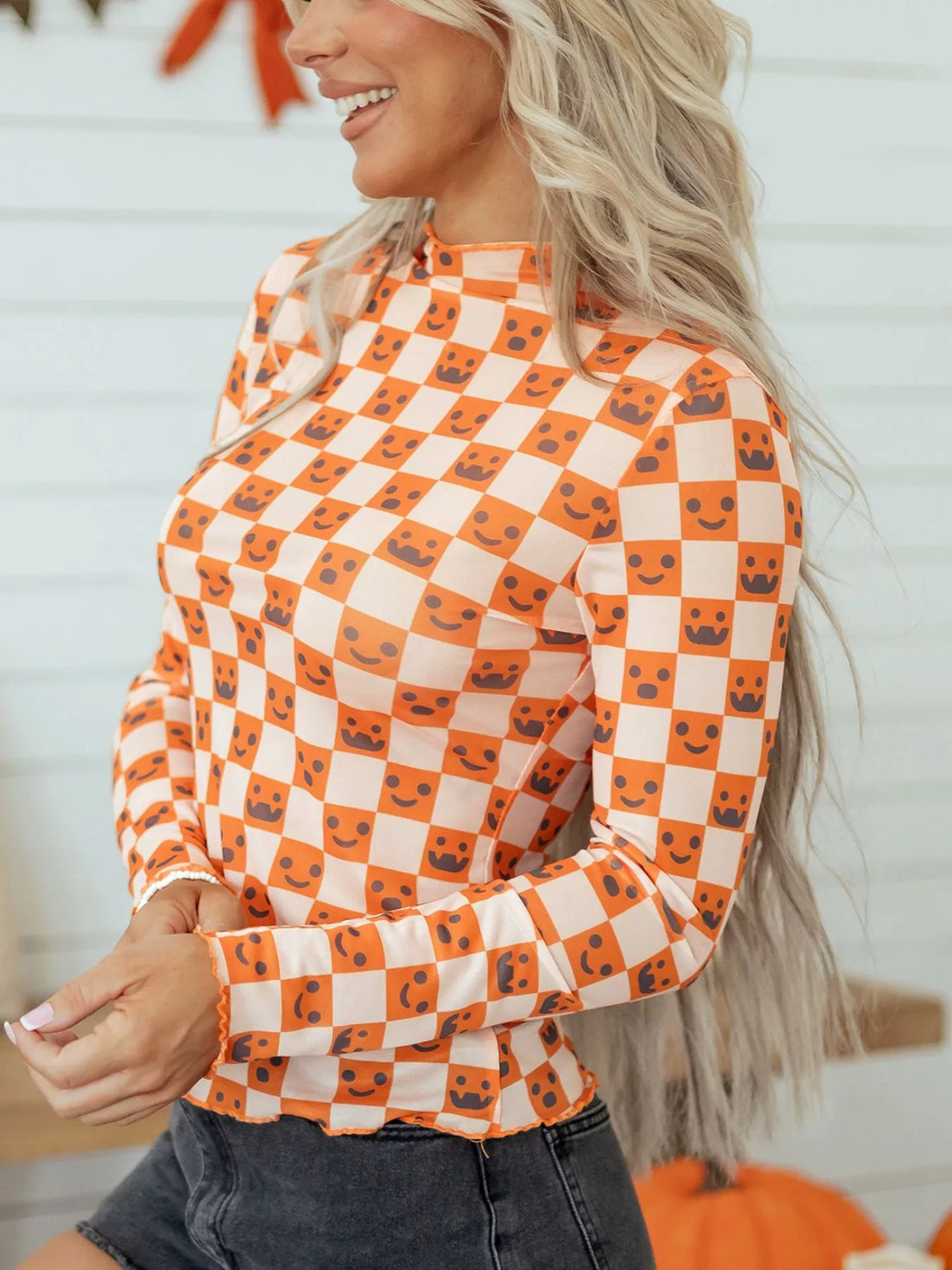 Halloween long sleeve mock neck blouse, side view, orange-and-white check with jack-o’-lantern faces