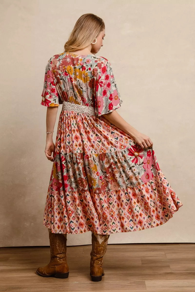 Back view floral print tiered midi dress with flutter sleeves and gathered waist