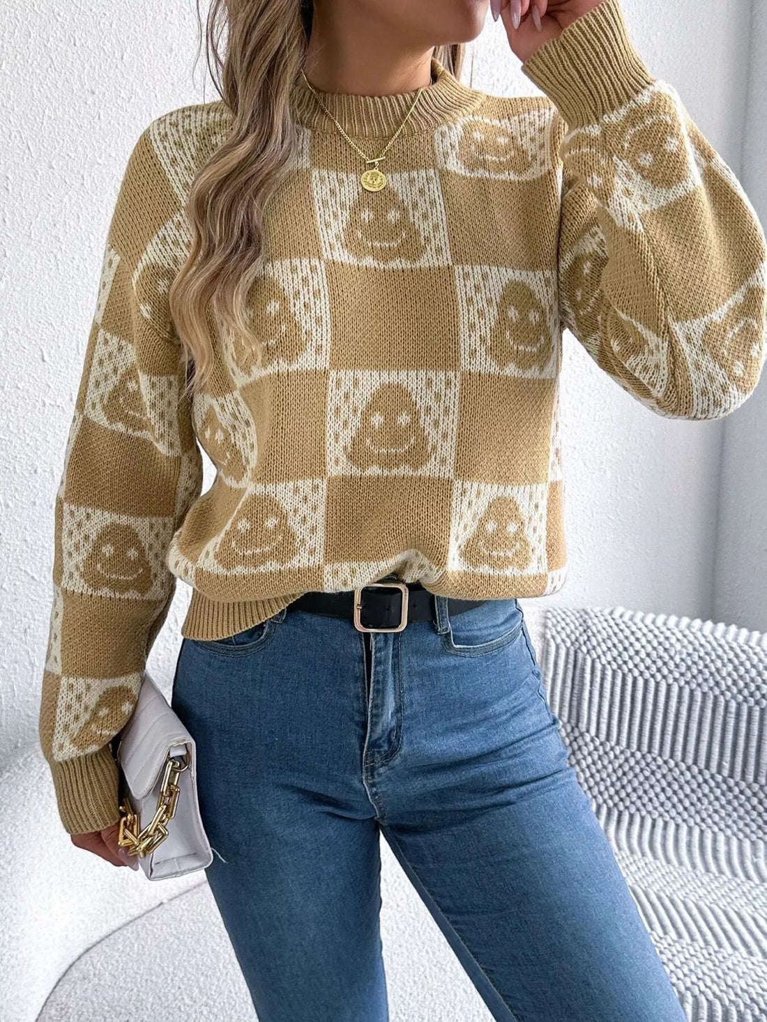 Ghost-pattern checkered round-neck sweater in tan and cream, long sleeves.