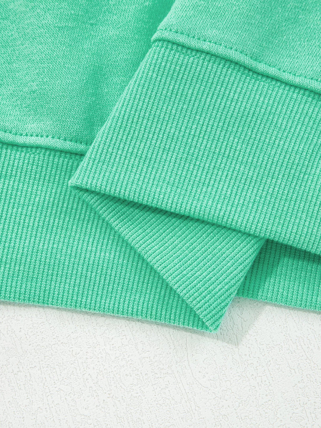 Turquoise ribbed cuff and sleeve hem detail on sweatshirt
