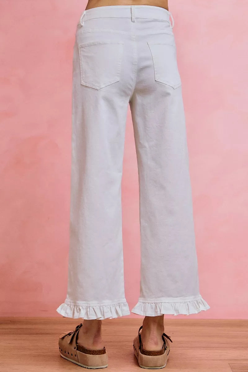 White mid-rise wide-leg jeans with ruffled cuffs and back patch pockets