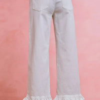 White mid-rise wide-leg jeans with ruffled cuffs and back patch pockets