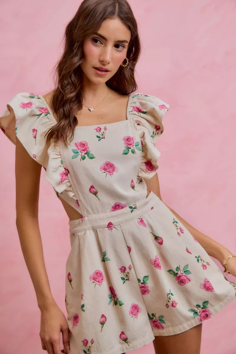 Ivory floral romper with ruffled cap sleeves and gathered waist, pink rose print