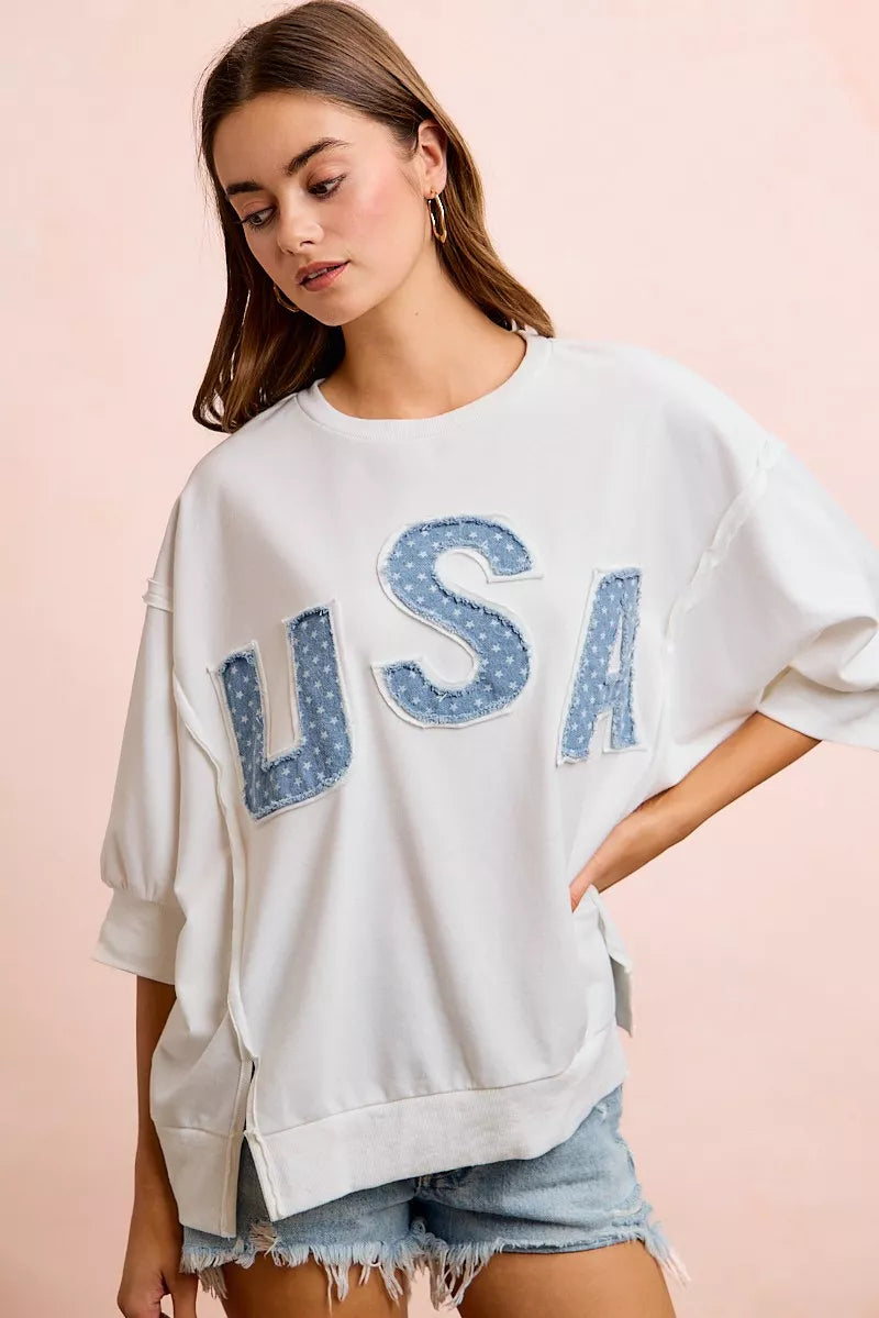 Ivory french terry pullover top with blue "USA" letter applique and draped dolman sleeves