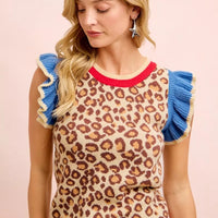 Leopard print knit top with blue ruffled sleeves and red-striped ribbed hem