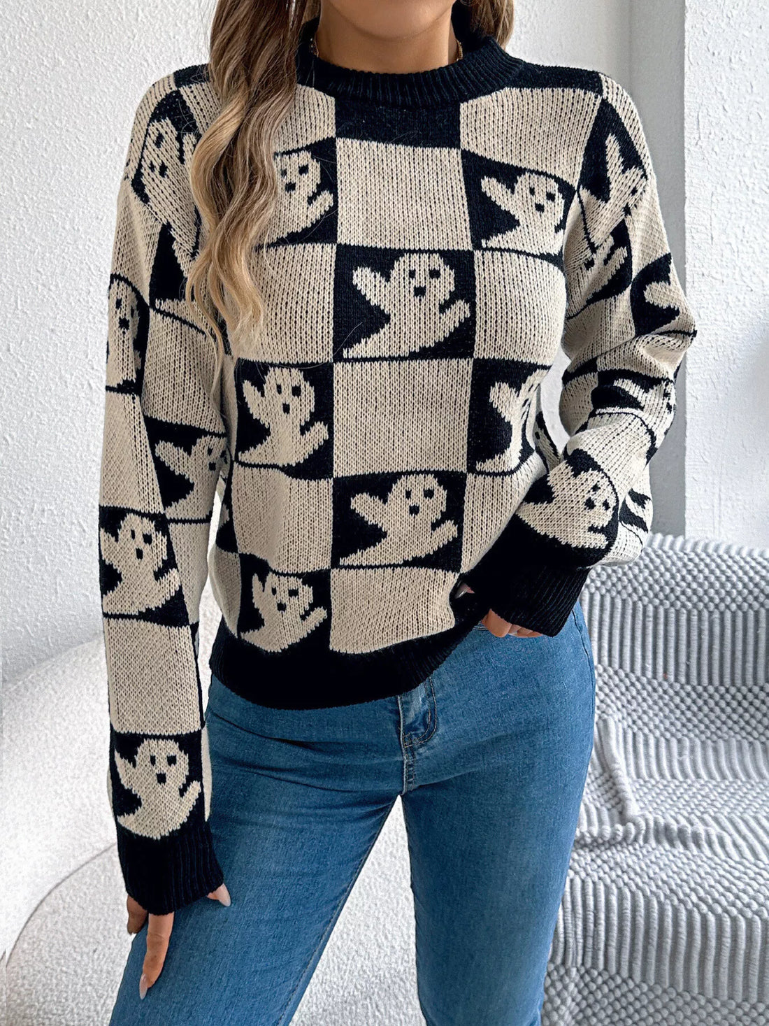 Ghost-pattern checkered round-neck sweater in black and cream, front view.
