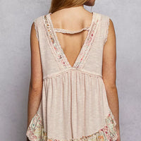 Pale pink sleeveless top with lace V-back and floral ruffle hem