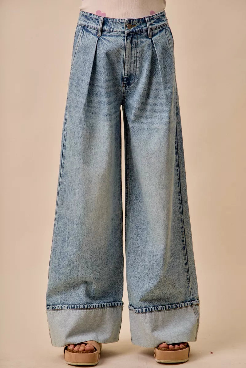 Light-wash mid-rise denim jeans with pleated wide-leg silhouette and button closure