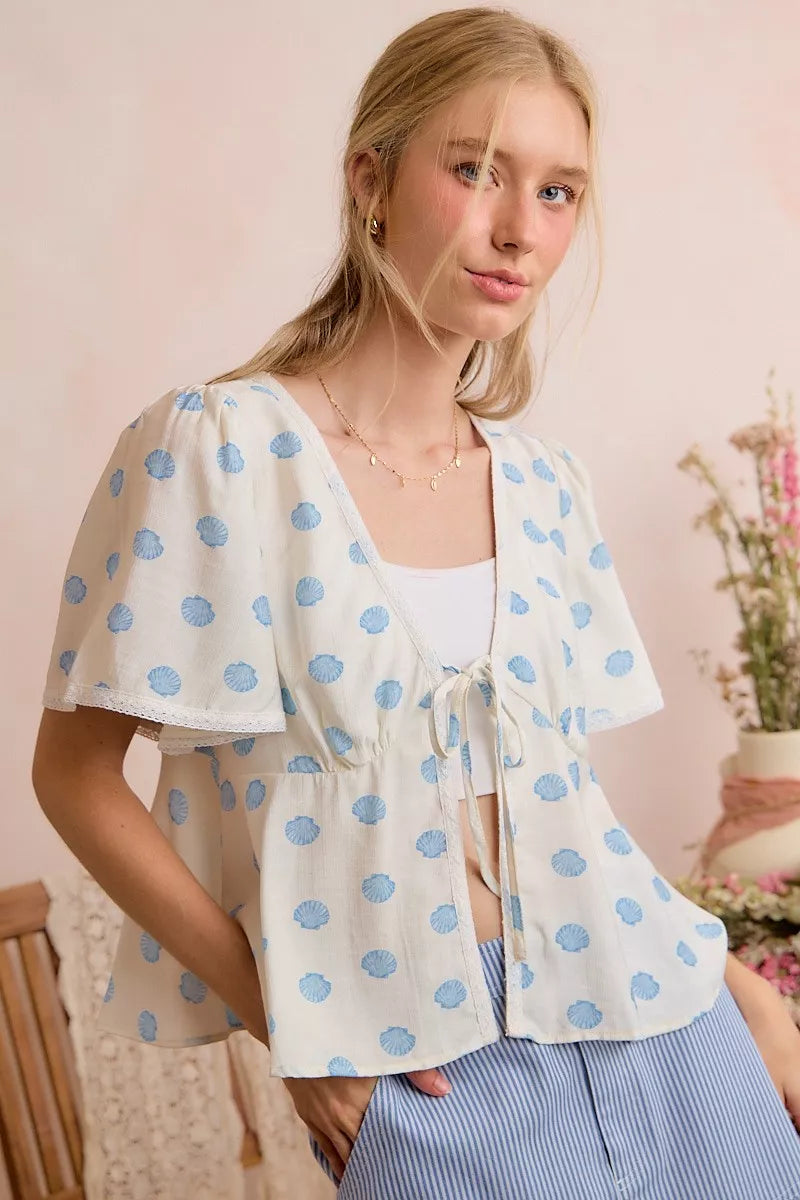 Ivory shell-print blouse with V neckline and tie-front, flutter sleeves
