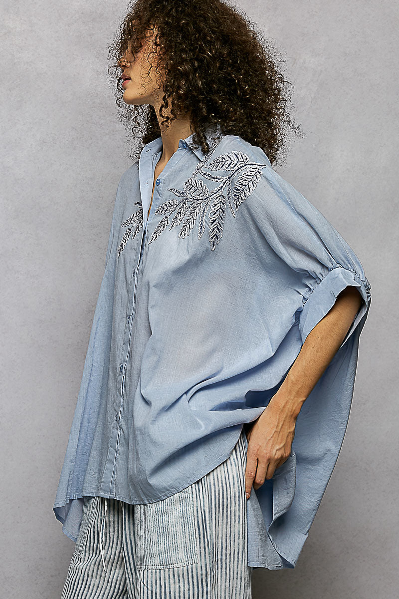 Sky blue button-down embroidered shirt with elbow-length sleeves and side drape