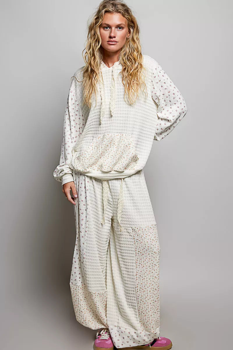 Cream knit hoodie with floral print sleeves and kangaroo pocket, front view