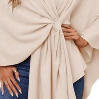 Close-up of ivory shawl cape front tie with gathered pleats at the waist